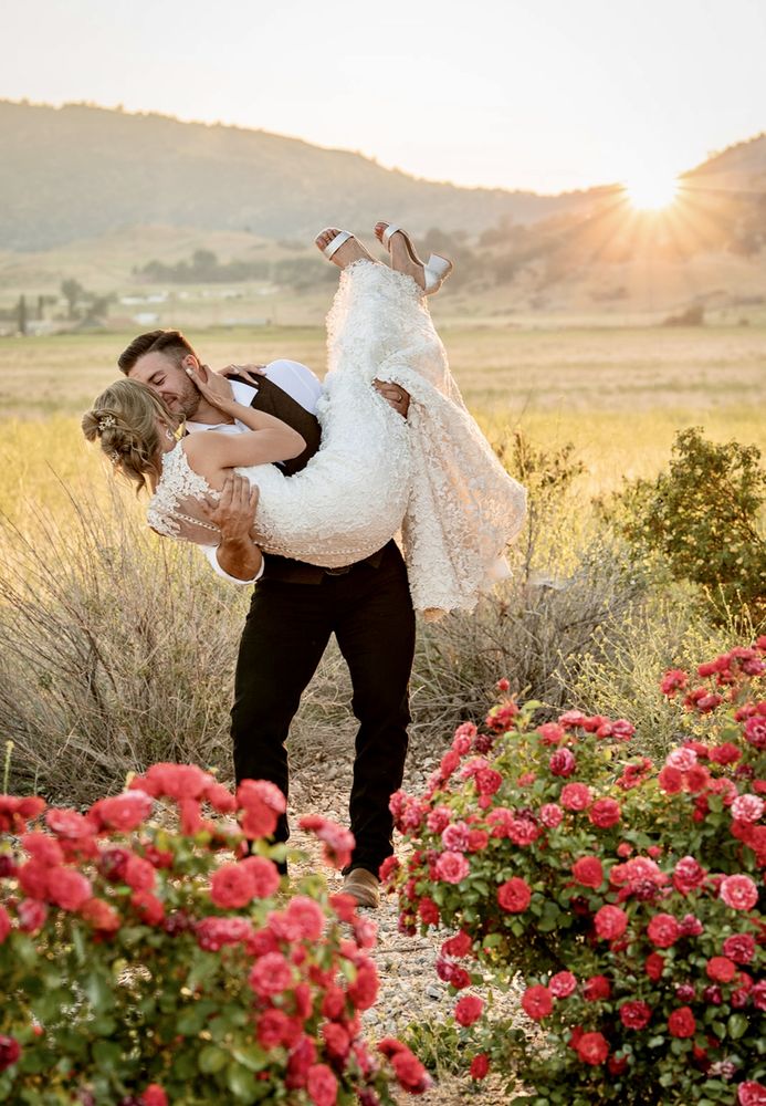 Groom lifting his bride at sunset, bride in a designer wedding gown - Strictly Weddings Phoenix AZ