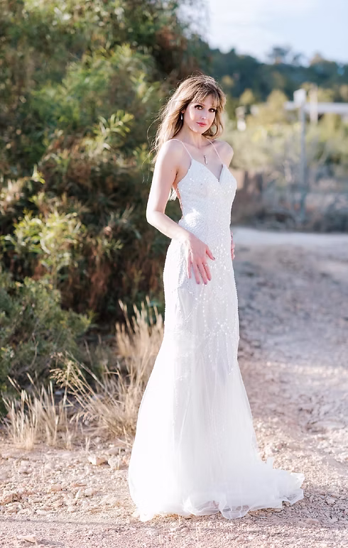 Bride smiling in an affordable designer lace wedding dress in a field - Strictly Weddings Phoenix AZ