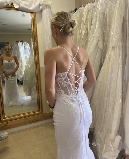Bride in a lace-up corset-back wedding dress in the showroom - Strictly Weddings Phoenix AZ